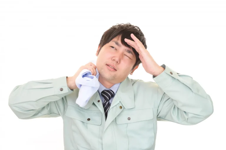汗を拭いている作業員の男性