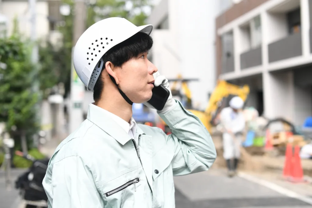 電話をかける作業服の男性