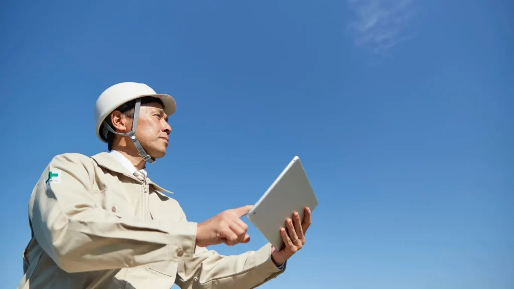 タブレットを持つ作業服の男性